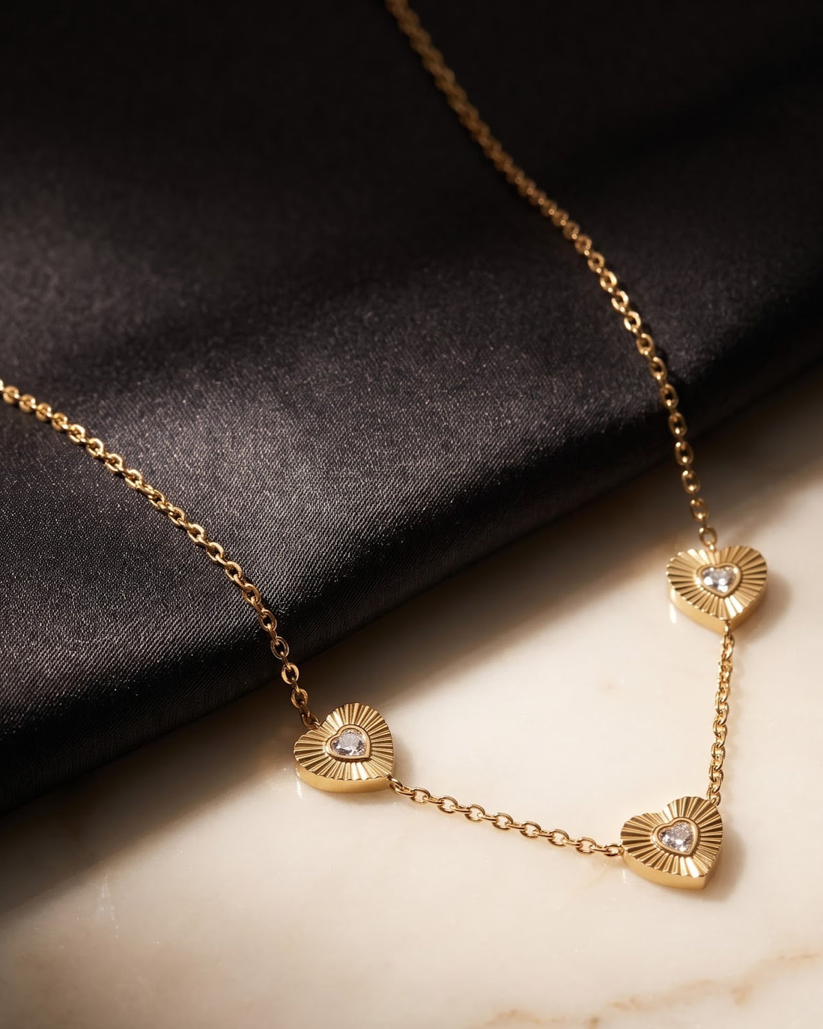 Close-up detail of the Solita Trio Heart Chain Necklace fluted heart stations and CZ stones