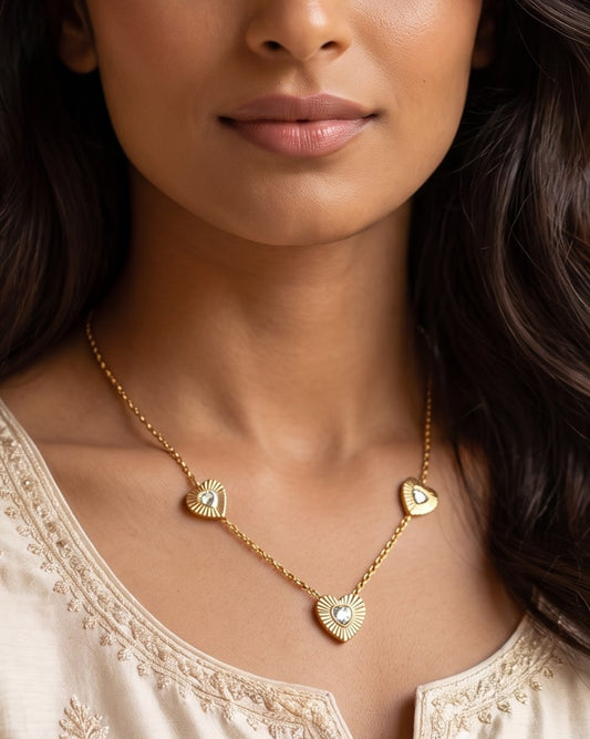 Woman wearing the Solita Trio Heart Chain Necklace at the collarbone