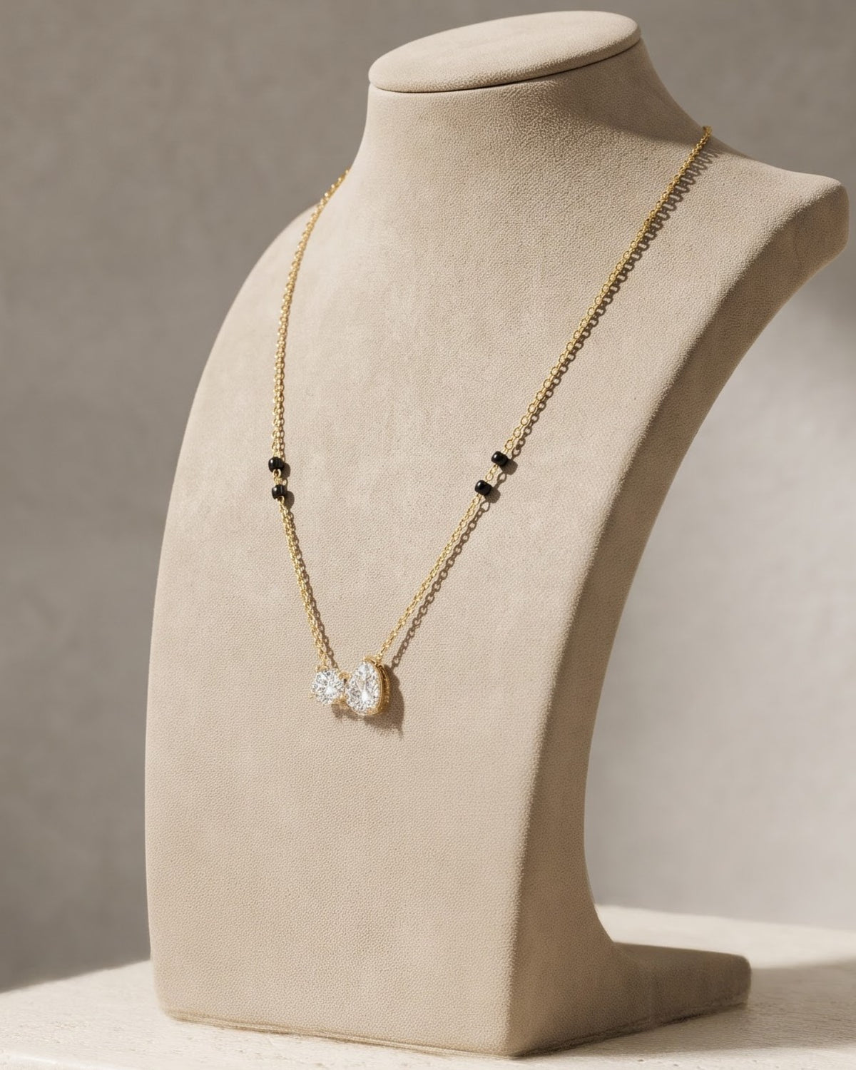 Solveya Drop Duo Mangalsutra displayed on a jewelry stand showing chain length