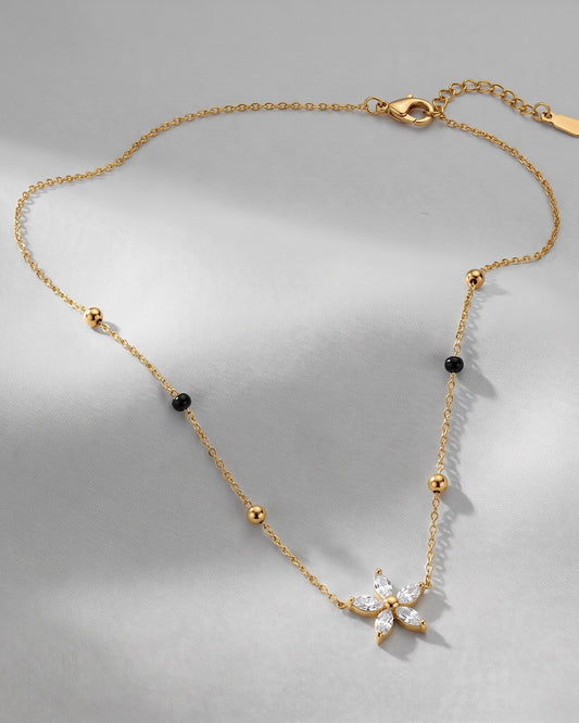 Solyssa Blossom Mangalsutra — a six-petal marquise cubic zirconia flower on gold-tone chain with black beads, hero shot, laid flat