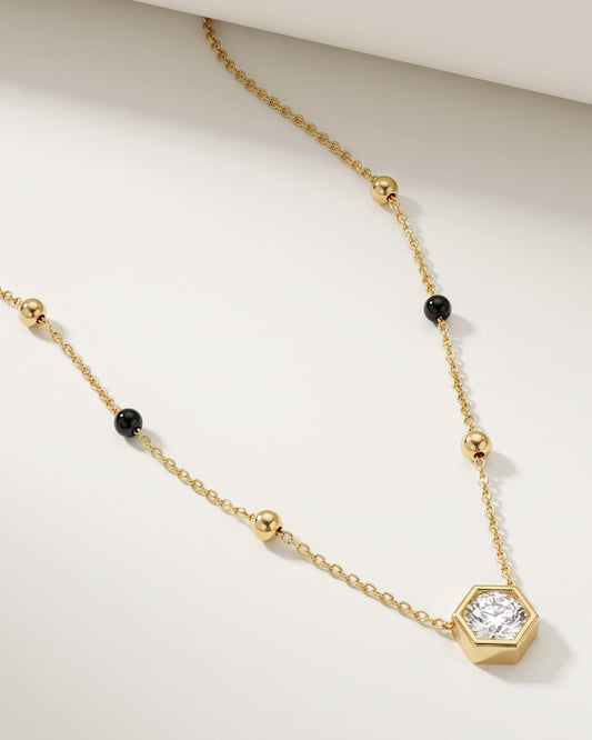 Solvexa Hexagon Mangalsutra — a bezel-set hexagon cubic zirconia solitaire on gold-tone chain with black beads, hero shot, laid flat