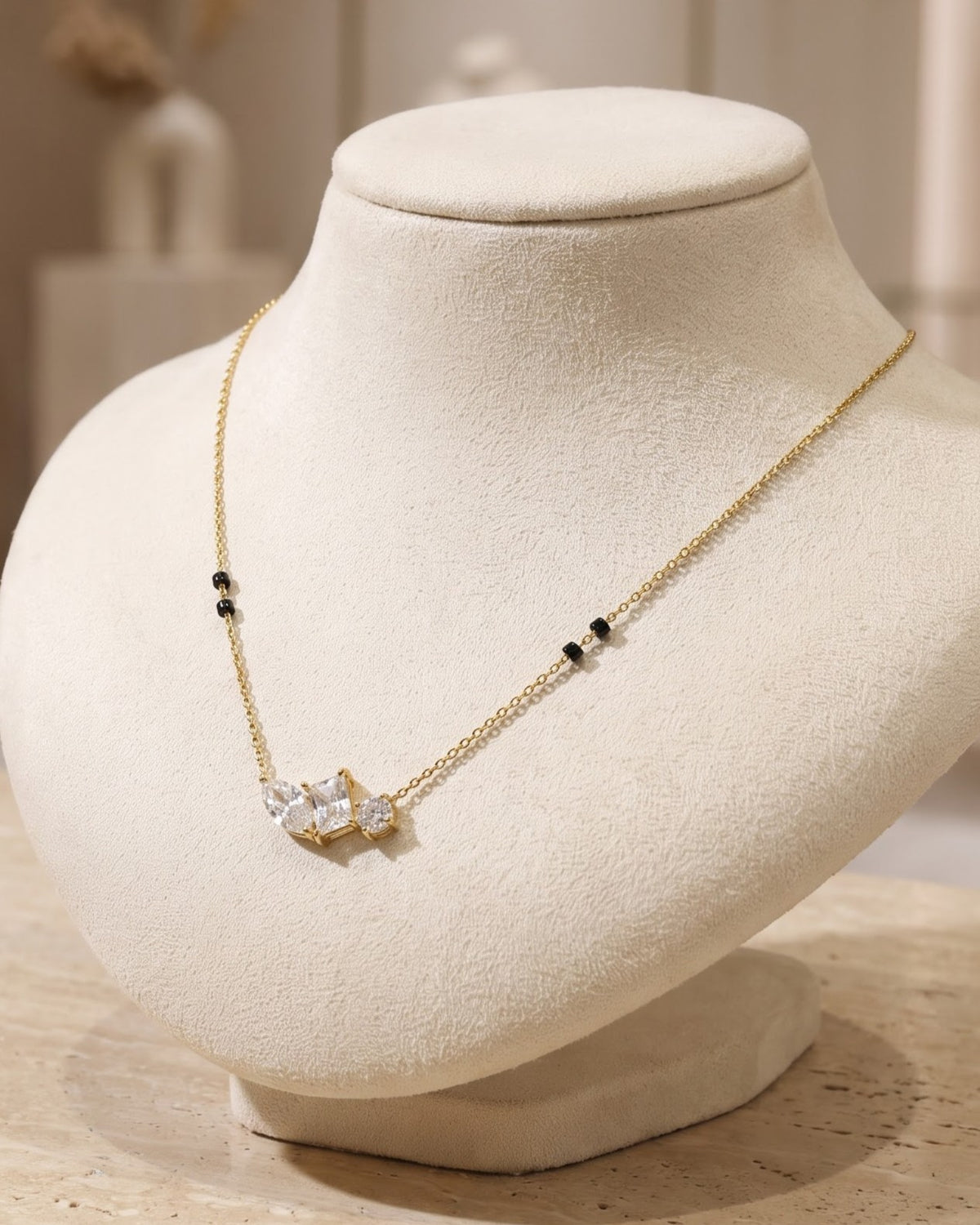 Solyra Stone Trio Mangalsutra displayed on a jewelry stand showing chain length
