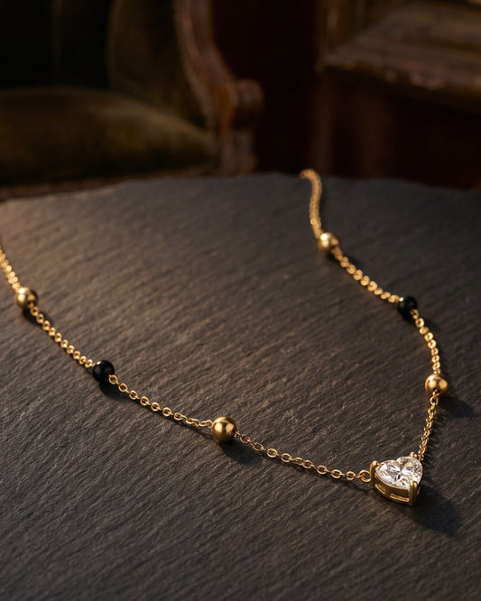 Solura Heart Mangalsutra — a heart-shaped cubic zirconia pendant on gold-tone chain with black beads, hero shot, laid flat