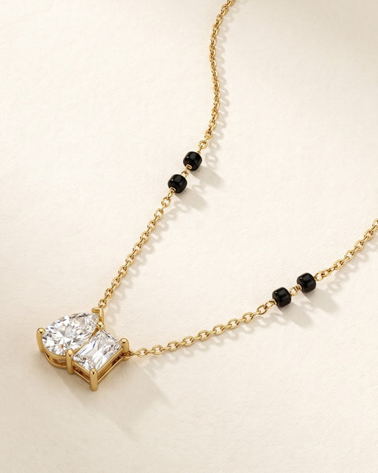 Solyna Teardrop Duo Mangalsutra — a pear-cut and baguette-cut cubic zirconia duo on gold-tone chain with black beads, hero shot, laid flat