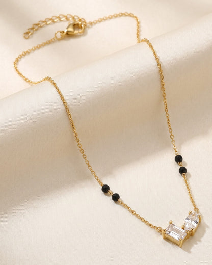 Solvana Baguette Duo Mangalsutra — a baguette and oval cubic zirconia duo on gold-tone chain with black beads, hero shot, laid flat