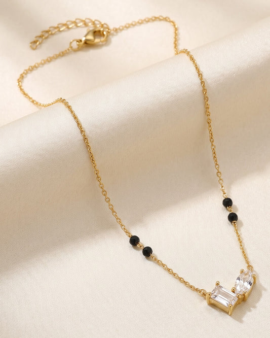 Solvana Baguette Duo Mangalsutra — a baguette and oval cubic zirconia duo on gold-tone chain with black beads, hero shot, laid flat