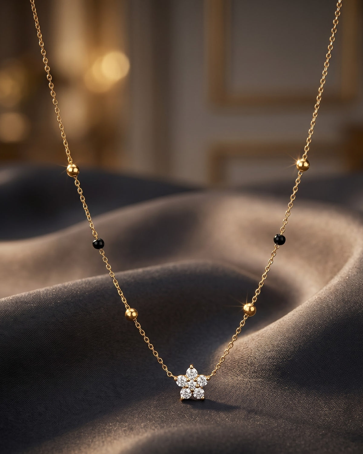 Solmira Petal Bloom Mangalsutra — a five-petal round cubic zirconia flower on gold-tone chain with black beads, hero shot, laid flat