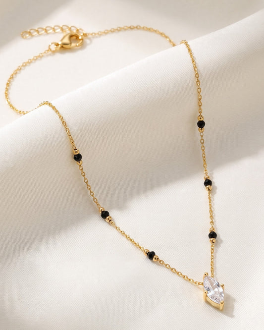Solvena Marquise Solitaire Mangalsutra — a marquise-cut cubic zirconia solitaire on gold-tone chain with black beads, hero shot, laid flat