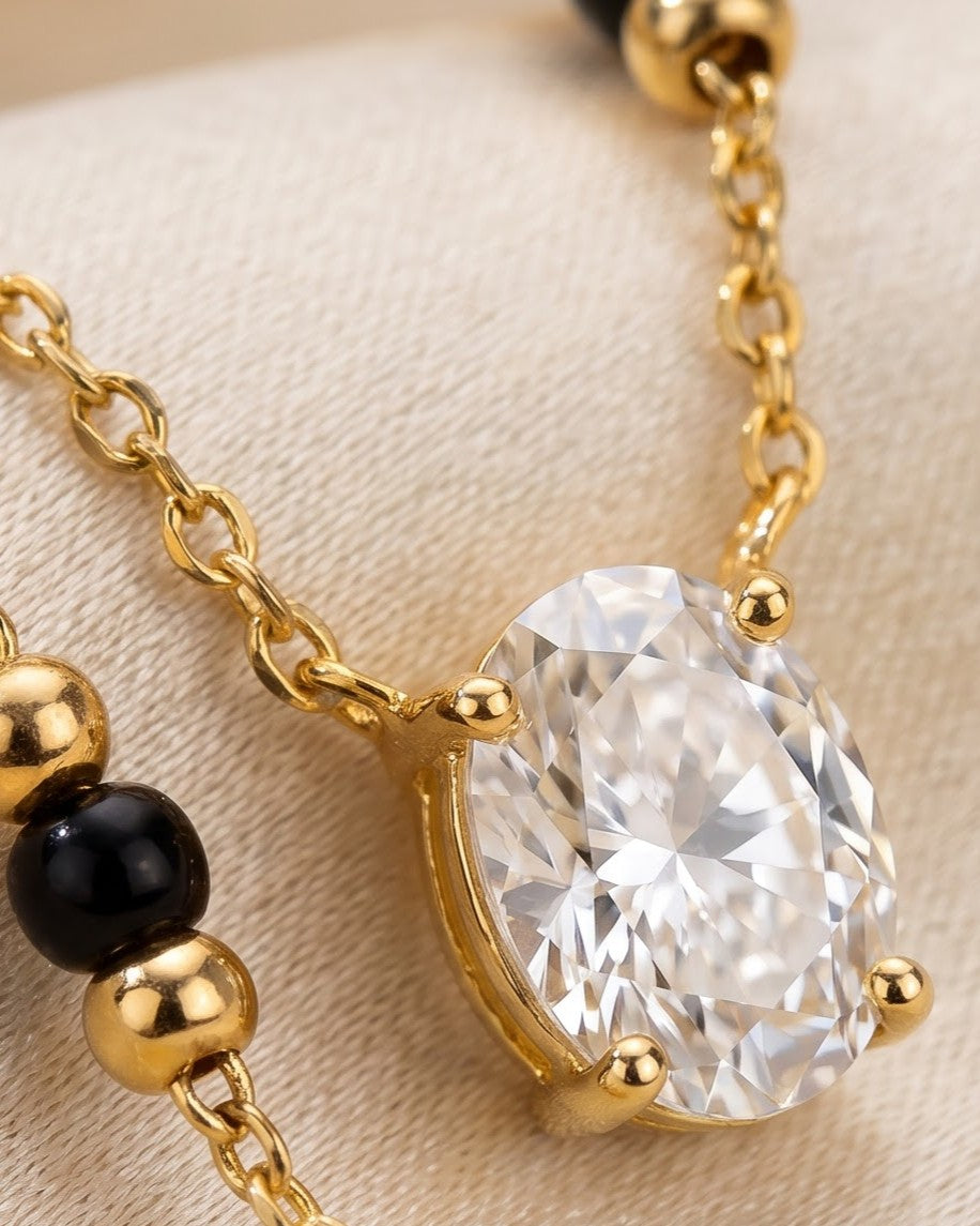 Cinematic close-up of the Solyne Oval Solitaire Mangalsutra chain and a bezel-set oval cubic zirconia solitaire