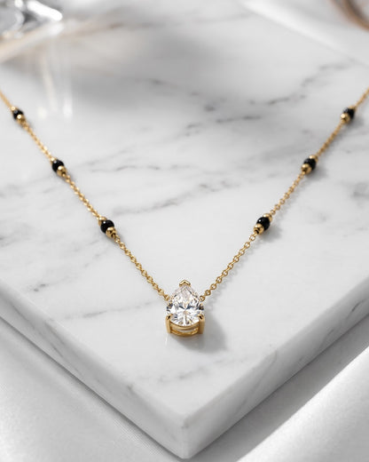 Solveth Drop Solitaire Mangalsutra — a pear-cut cubic zirconia solitaire on gold-tone chain with black beads, hero shot, laid flat